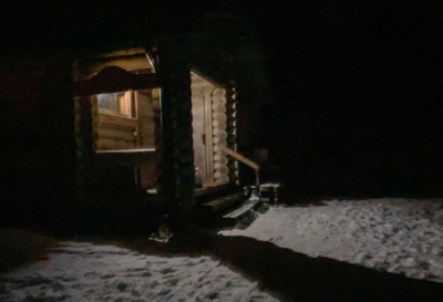 Hangasjärven saunan sisäänkäynti lumisena iltana.
