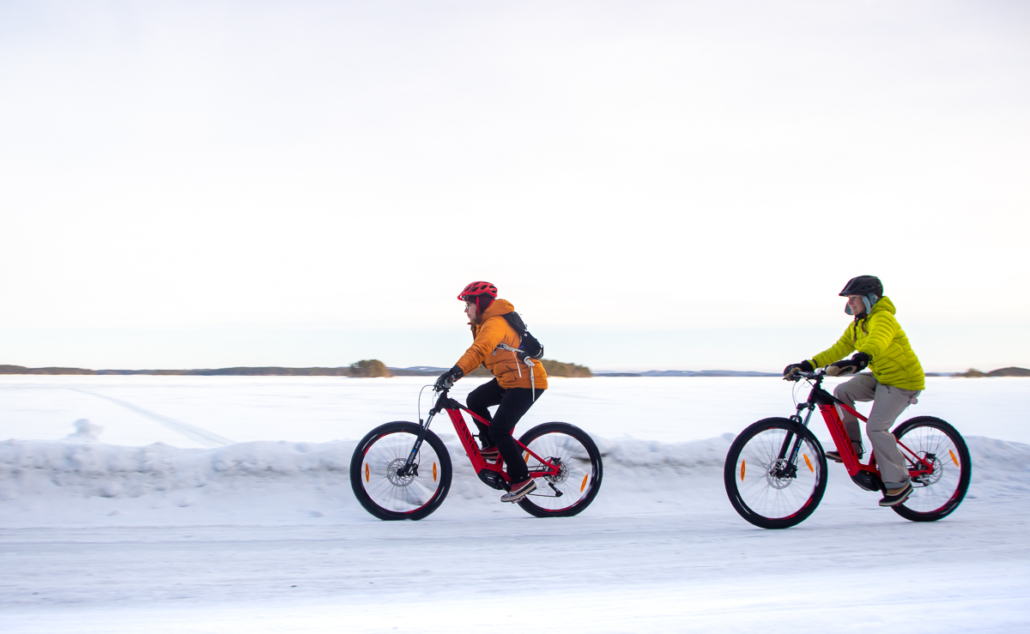 Kaksi sähköpyöräilijää talvivarusteissa Pielisen rannalla. Kuva: Tom Toivonen