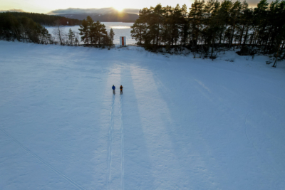 Hiekkasaari ja taustalla Kolin huiput. Edustalla kaksi hiihtäjää lumisella Pielisellä. Kuva: Tom Toivonen