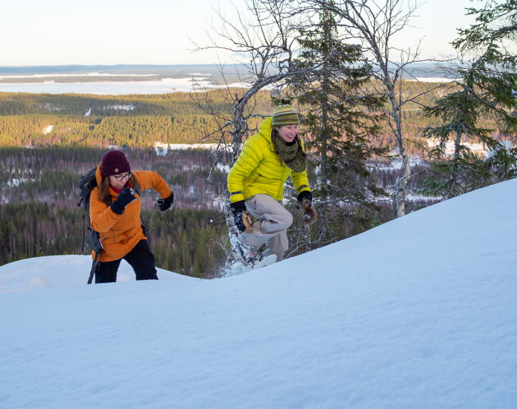 Kaksi lumikenkäilijää yrittää laittaa juoksuksi Ryläyksen maisemissa. Kuva: Tom Toivonen